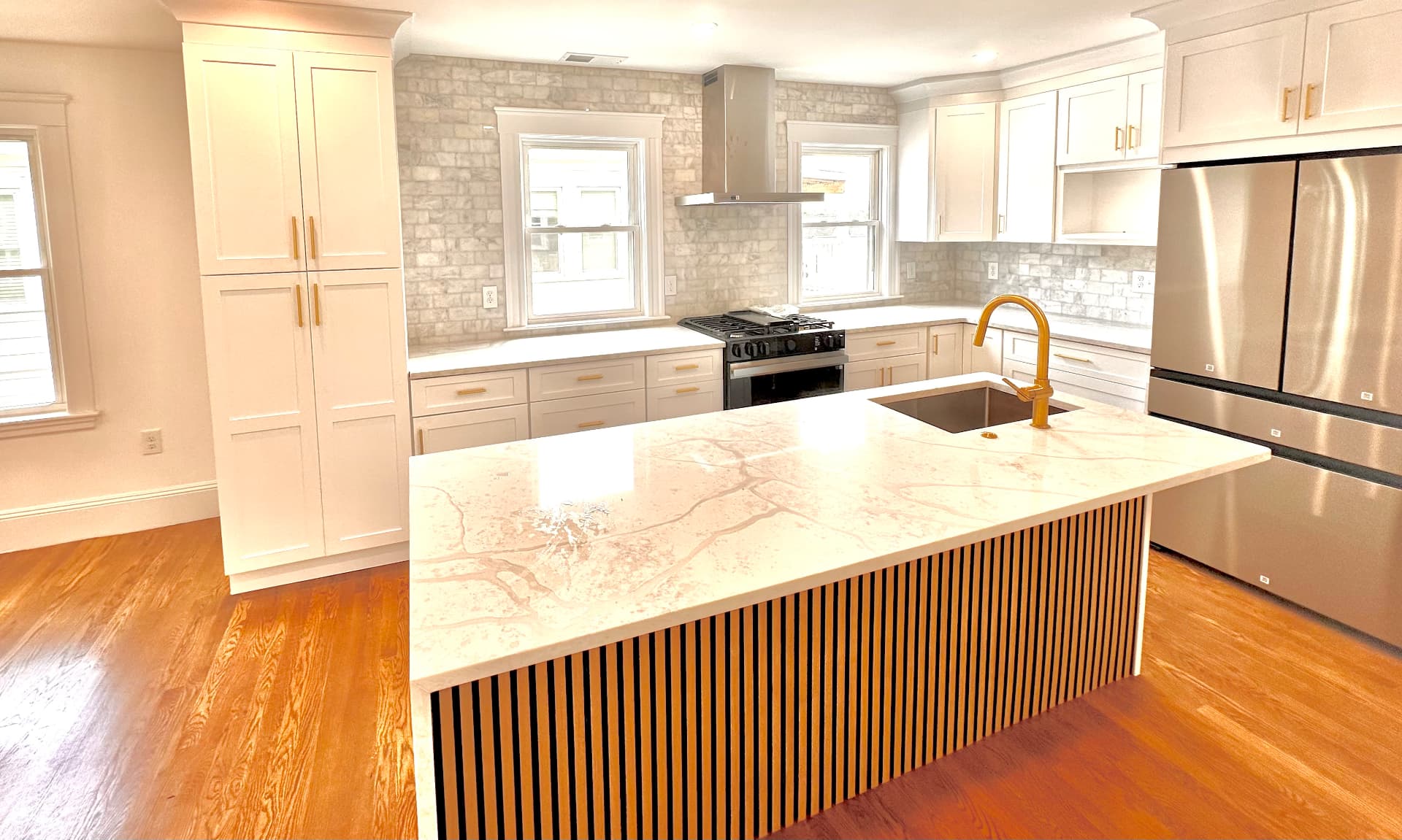 Finished kitchen with quartz waterfall island and fluted oak base