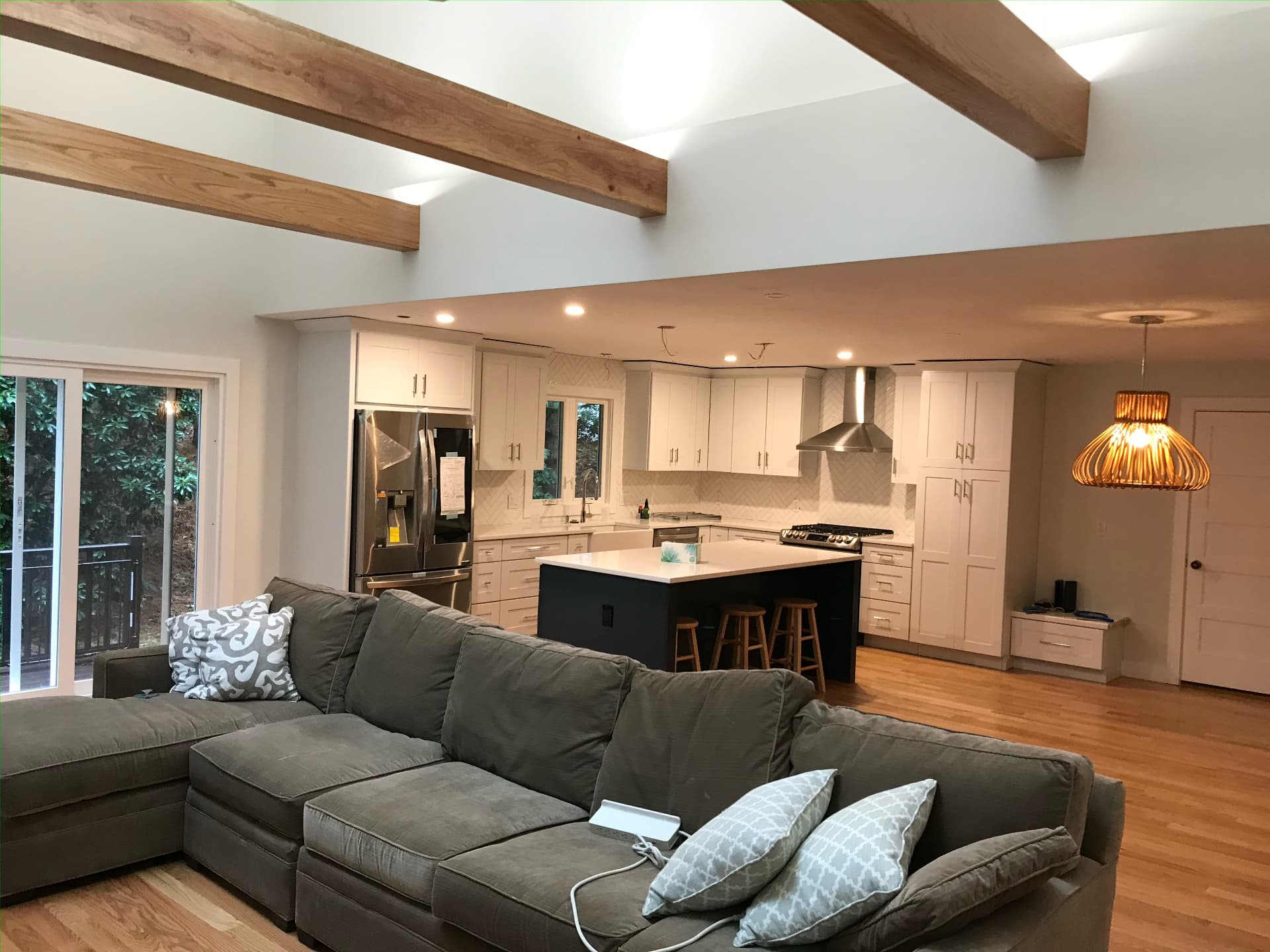 Open-concept kitchen and living room with exposed wood ceiling beams