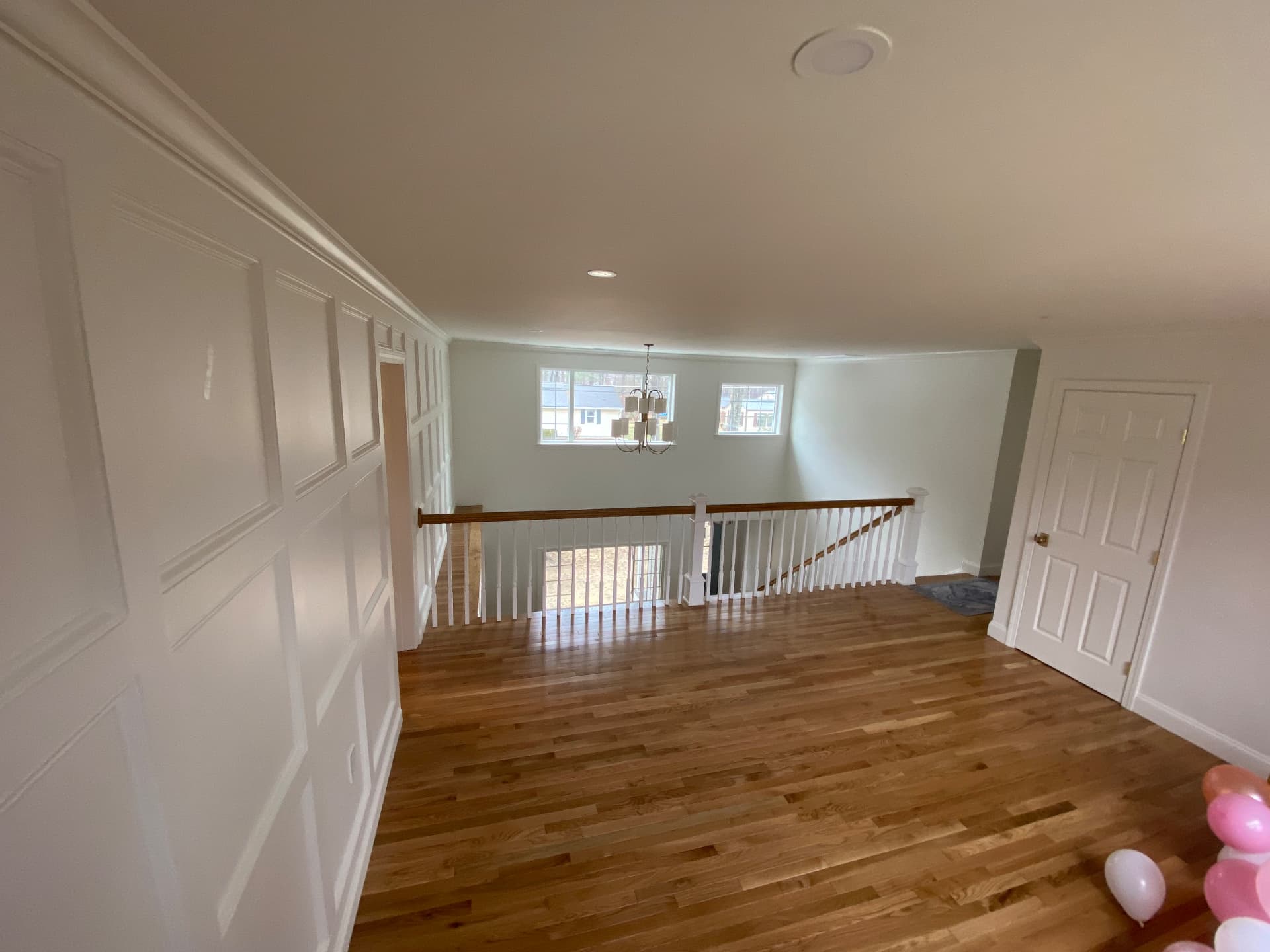 Upstairs landing with wainscot paneling and oak flooring