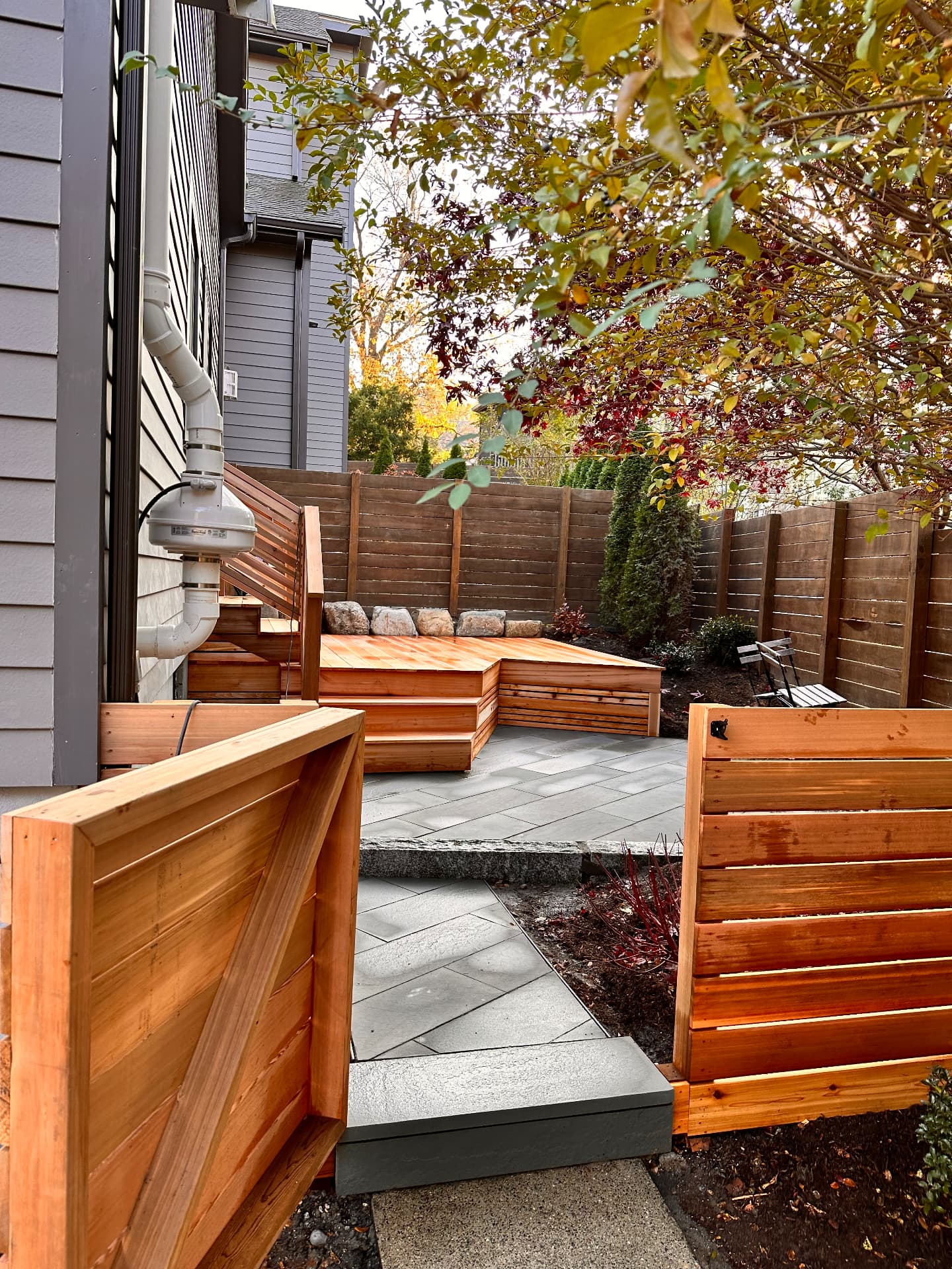 Cedar gate opening onto the finished patio and deck