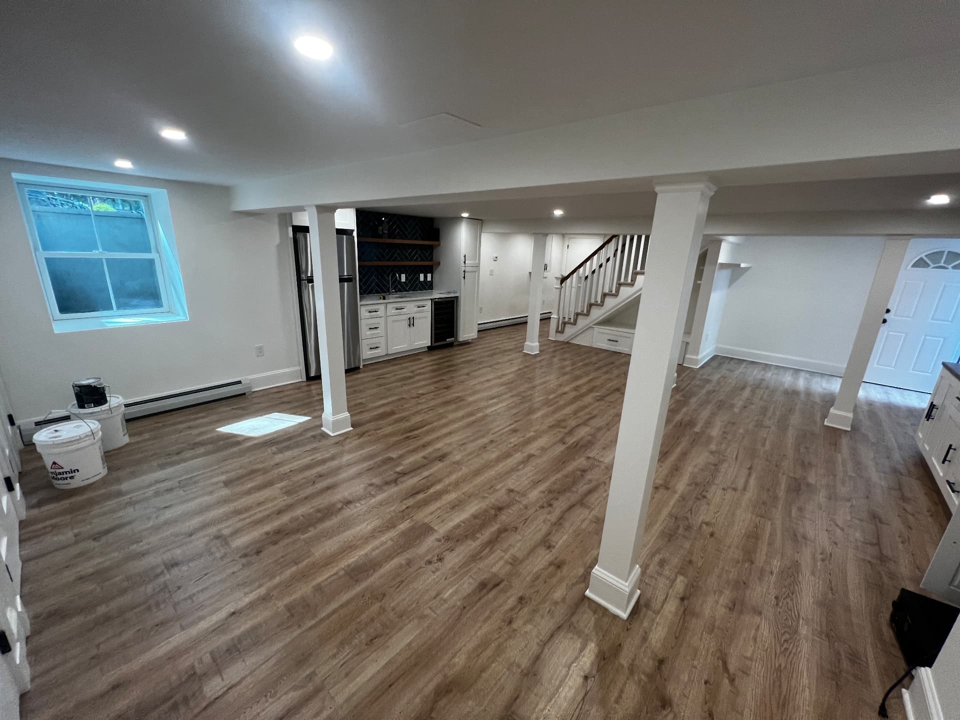 Open basement living area with wet bar and rebuilt staircase