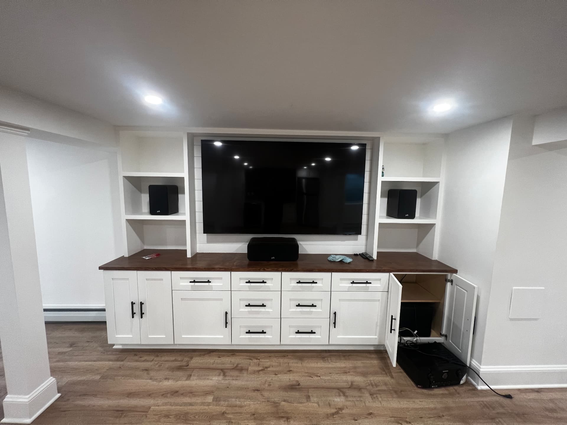 Custom media wall with shiplap panel, walnut counter and cabinetry