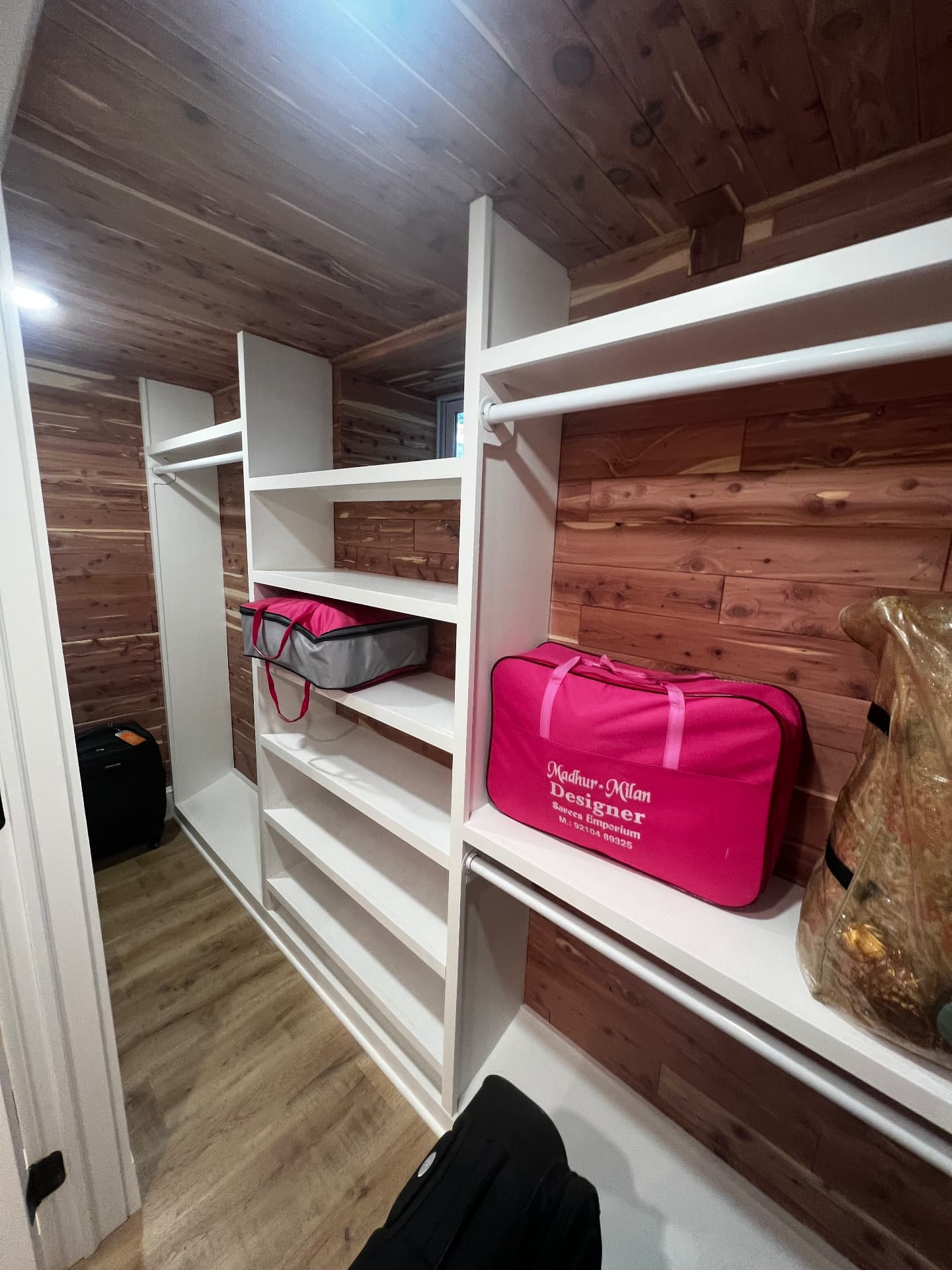 Cedar-lined storage closet with white shelving and hanging rods