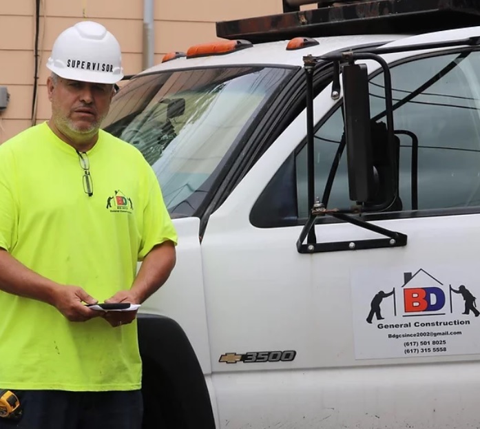 BDGC supervisor on site beside a company truck with the BDGC General Construction logo