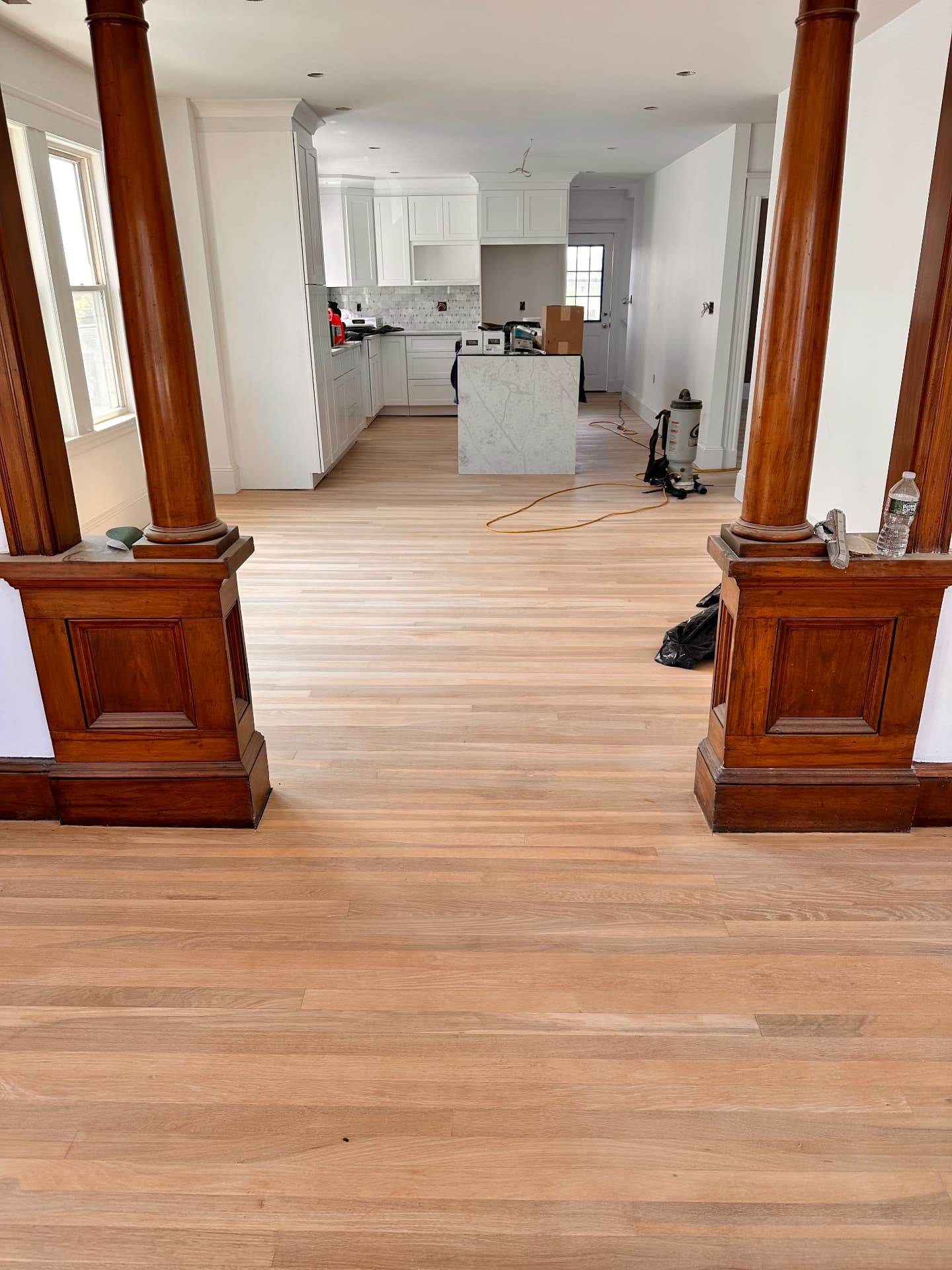 New white oak flooring installed through the open living and kitchen area