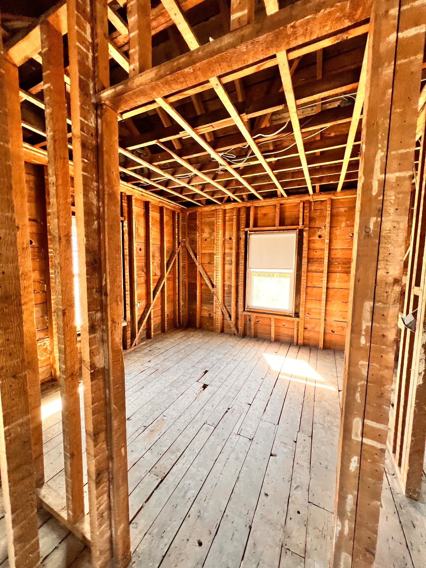 Open framing of a bedroom taken down to studs and joists