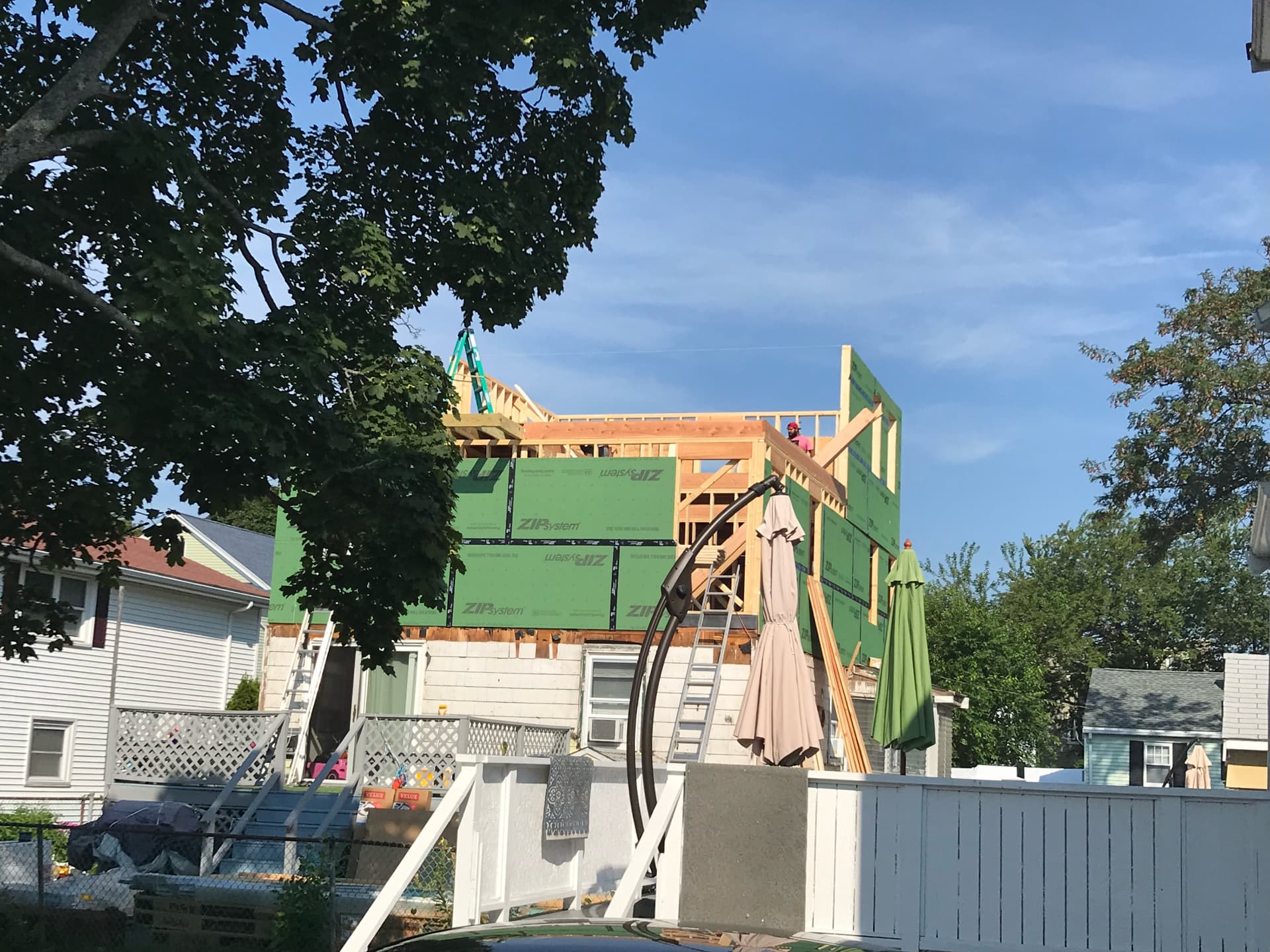 Second-story framing underway over the existing roofline